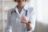 Close up smiling young doctor holding piggy bank in hands.